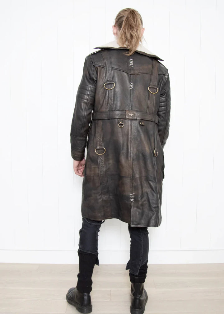 Person wearing a long leather coat with a white background