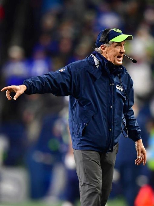Person in a blue jacket and cap on a sports field