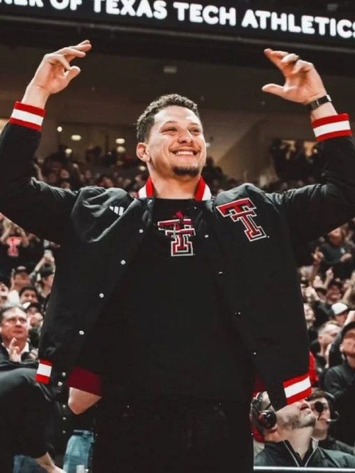 Person wearing a black jacket with Texas Tech logos in an indoor sports arena.