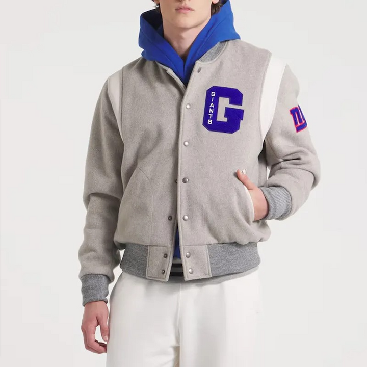 Person wearing a gray varsity jacket with blue hood and 'GIANTS' logo on a white background